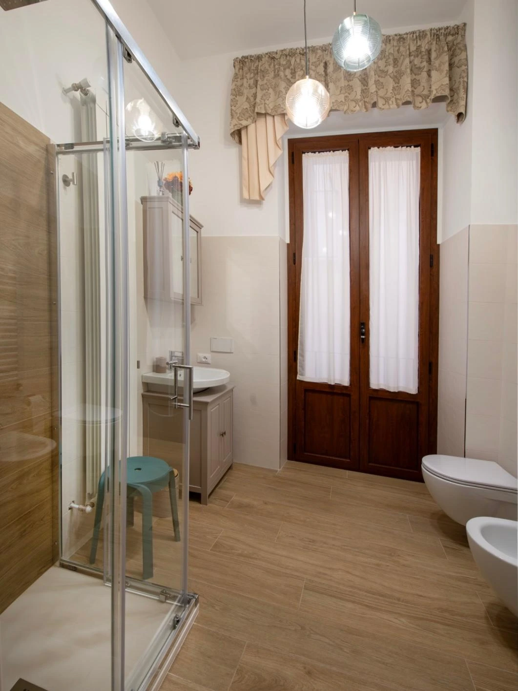 Il bagno della Dimora, con doccia e porta-finestra su un piccolo balcone